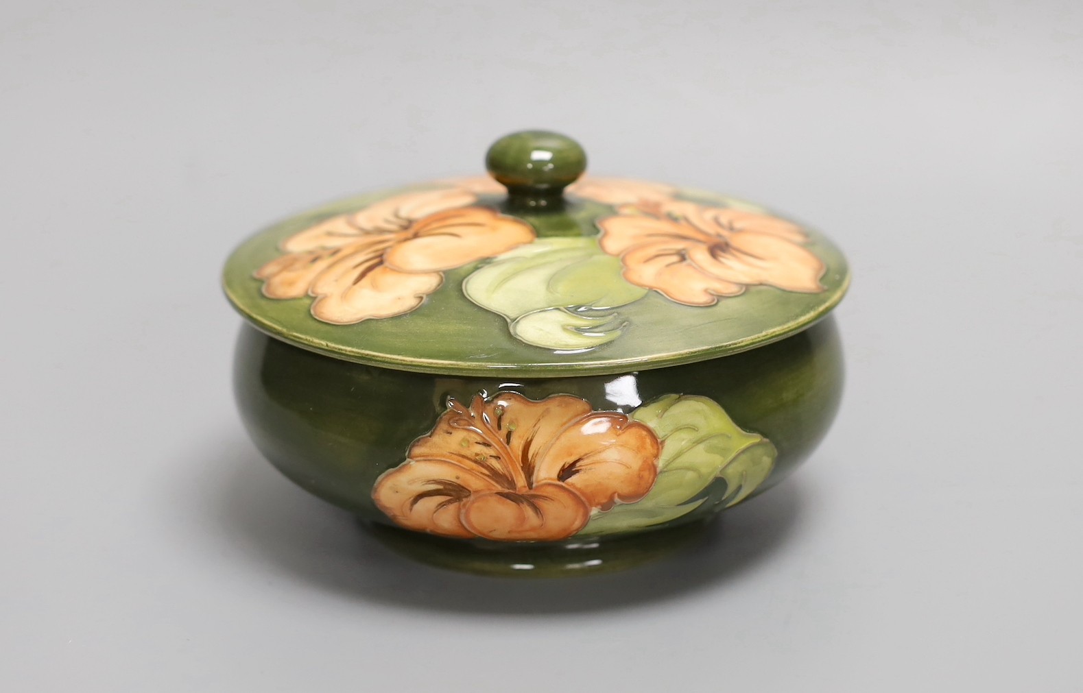 A Moorcroft hibiscus pattern powder bowl and cover, 15cm diam.